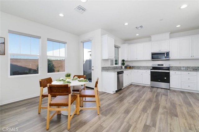 16050 Aventurine Ln, Chino, CA 91708 - kitchen with stainless steel appliances, white cabinets, light wood-type flooring, light stone countertops, and recessed lighting
