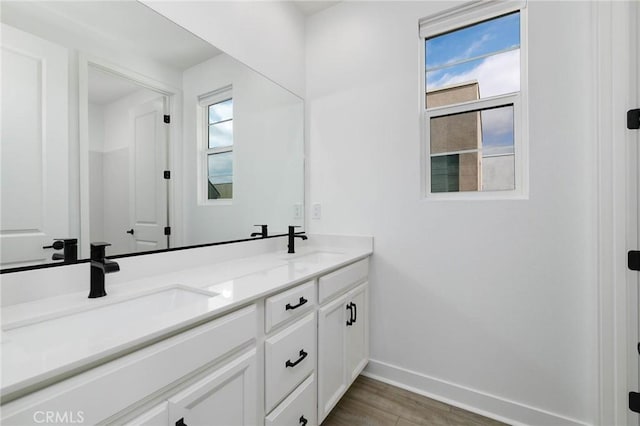 484 Chorus, Irvine, CA 92618 - bathroom featuring double vanity, baseboards, and wood finished floors