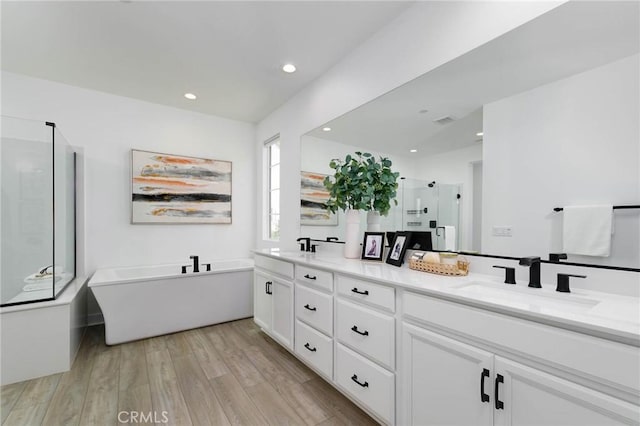 484 Chorus, Irvine, CA 92618 - bathroom with a shower stall, double vanity, a freestanding tub, recessed lighting, and wood finished floors