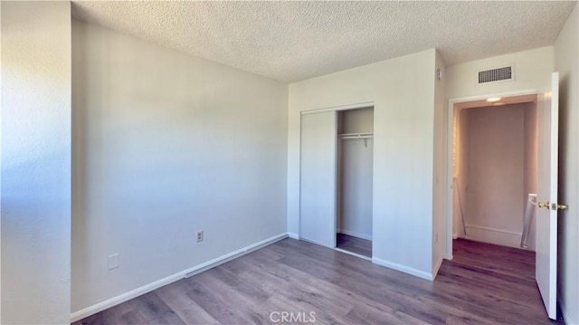 9047 Langdon Ave Unit 28, North Hills, CA 91343 - unfurnished bedroom with wood finished floors, a textured ceiling, a closet, and baseboards