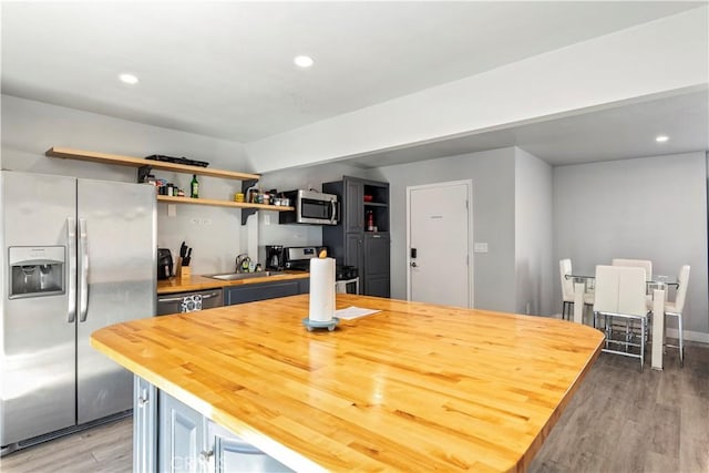134 Palm Ave, National City, CA 91950 - kitchen with stainless steel appliances, wood counters, light wood-type flooring, a sink, and recessed lighting