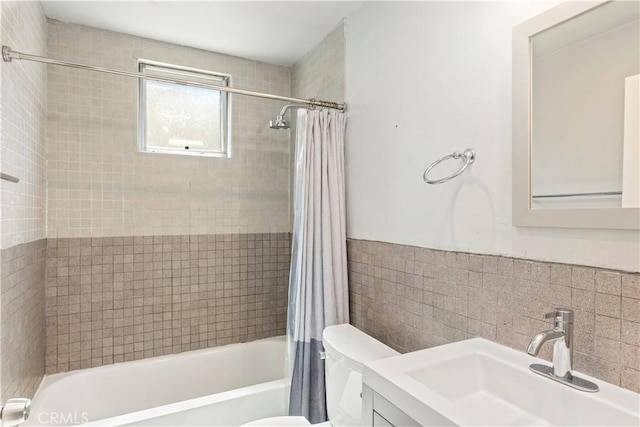 134 Palm Ave, National City, CA 91950 - full bath featuring shower / bath combo with shower curtain, toilet, vanity, tile walls, and a wainscoted wall