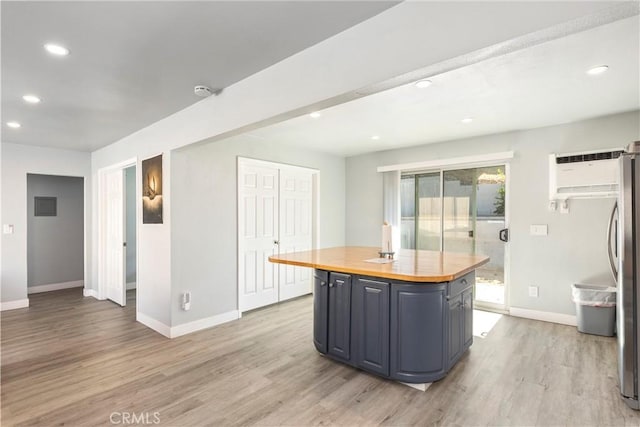 134 Palm Ave, National City, CA 91950 - kitchen with butcher block counters, baseboards, recessed lighting, light wood-style floors, and stainless steel fridge