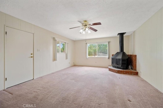 4038 Dartmouth Ln, Santa Maria, CA 93455 - unfurnished living room featuring a wood stove, ceiling fan, carpet floors, a textured ceiling, and a decorative wall