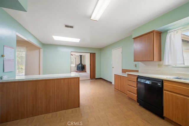 4038 Dartmouth Ln, Santa Maria, CA 93455 - kitchen featuring black dishwasher, light countertops, a sink, a skylight, and brown cabinets