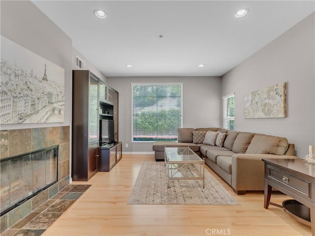 5637 Como Cir, Woodland Hills, CA 91367 - living room featuring a tiled fireplace, plenty of natural light, wood finished floors, and recessed lighting