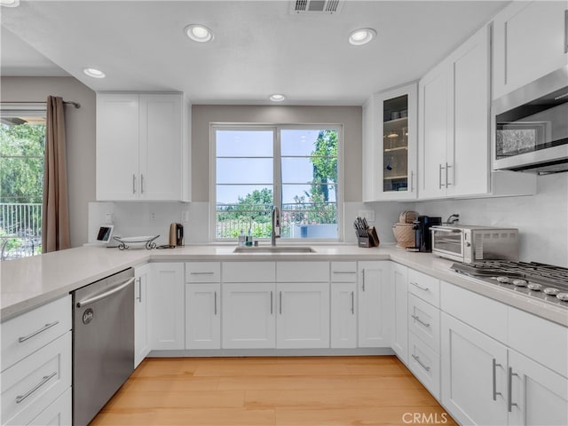 5637 Como Cir, Woodland Hills, CA 91367 - kitchen featuring appliances with stainless steel finishes, recessed lighting, healthy amount of natural light, white cabinetry, and light countertops