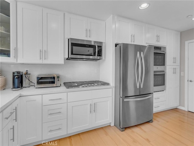 5637 Como Cir, Woodland Hills, CA 91367 - kitchen with appliances with stainless steel finishes, white cabinets, light countertops, recessed lighting, and glass insert cabinets