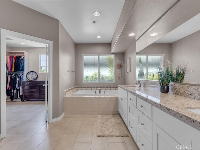 5637 Como Cir, Woodland Hills, CA 91367 - bathroom with healthy amount of natural light, a garden tub, double vanity, a spacious closet, and recessed lighting