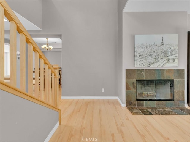 5637 Como Cir, Woodland Hills, CA 91367 - unfurnished living room with wood finished floors, a chandelier, a tiled fireplace, and stairs
