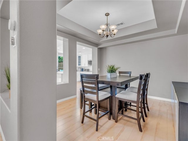 5637 Como Cir, Woodland Hills, CA 91367 - dining area with a chandelier, light wood-type flooring, and a raised ceiling