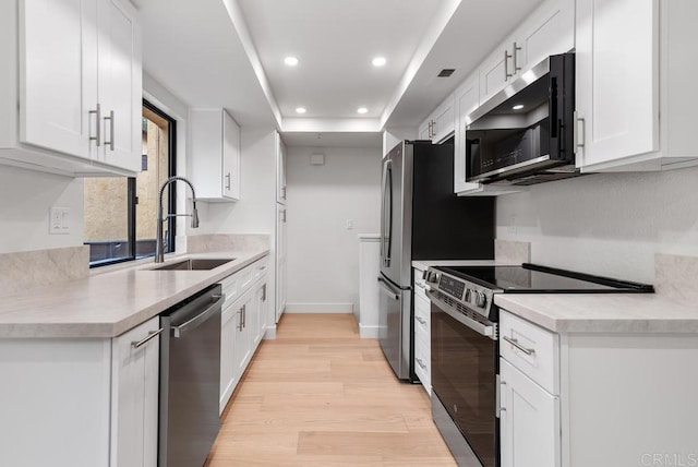 1680 N Coast Highway 101 Unit 36, Encinitas, CA 92024 - kitchen with appliances with stainless steel finishes, light wood-style flooring, white cabinets, recessed lighting, and light countertops