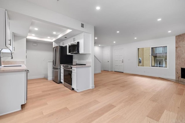 1680 N Coast Highway 101 Unit 36, Encinitas, CA 92024 - kitchen with appliances with stainless steel finishes, light countertops, recessed lighting, white cabinetry, and light wood-style floors