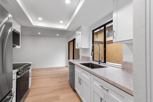 1680 N Coast Highway 101 Unit 36, Encinitas, CA 92024 - kitchen with appliances with stainless steel finishes, recessed lighting, white cabinetry, light countertops, and light wood-type flooring