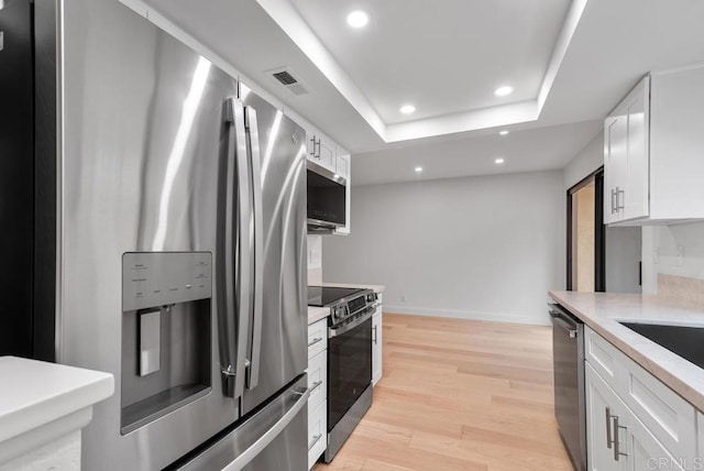 1680 N Coast Highway 101 Unit 36, Encinitas, CA 92024 - kitchen with appliances with stainless steel finishes, recessed lighting, white cabinetry, a raised ceiling, and light wood finished floors