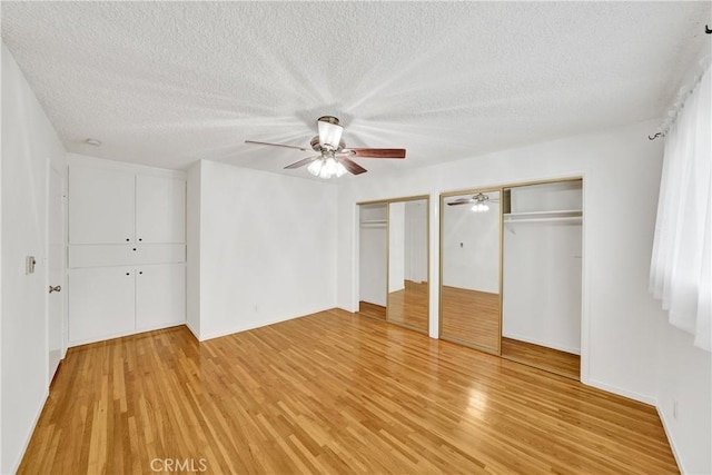 5140 E Atherton St Unit 22, Long Beach, CA 90815 - unfurnished bedroom featuring a textured ceiling, light wood-style flooring, two closets, ceiling fan, and baseboards