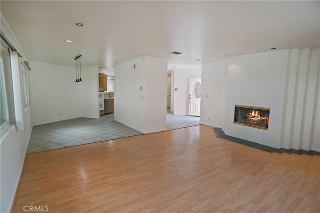 4182 Sunswept Dr, Studio City, CA 91604 - unfurnished living room with light wood-type flooring, a glass covered fireplace, recessed lighting, and baseboards