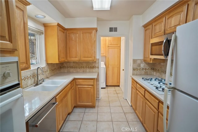 4182 Sunswept Dr, Studio City, CA 91604 - kitchen featuring stainless steel appliances, a sink, washer / clothes dryer, and light countertops