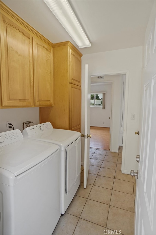 4182 Sunswept Dr, Studio City, CA 91604 - laundry room featuring independent washer and dryer, cabinet space, light tile patterned floors, and baseboards