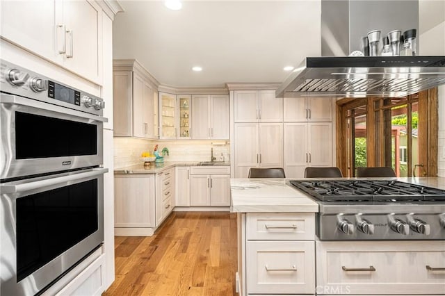 2902 E Trenton E, Orange, CA 92867 - kitchen featuring stainless steel appliances, wall chimney range hood, light wood-style flooring, backsplash, and recessed lighting