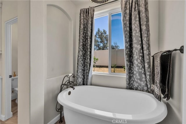 7988 Borrego Ct, Yucca Valley, CA 92284 - full bathroom featuring a freestanding bath, toilet, and baseboards