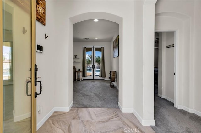 7988 Borrego Ct, Yucca Valley, CA 92284 - corridor with french doors, arched walkways, light colored carpet, baseboards, and recessed lighting