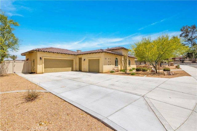 7988 Borrego Ct, Yucca Valley, CA 92284 - mediterranean / spanish house featuring an attached garage, stucco siding, a gate, a tile roof, and driveway