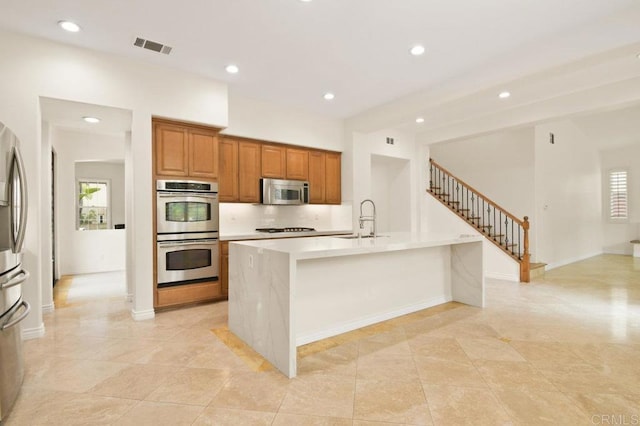 2413 Paseo, Los Gatos, Chula Vista, CA 91914 - kitchen featuring stainless steel appliances, recessed lighting, brown cabinets, light countertops, and a center island with sink