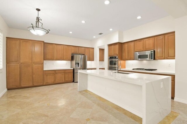 2413 Paseo, Los Gatos, Chula Vista, CA 91914 - kitchen featuring appliances with stainless steel finishes, brown cabinetry, an island with sink, light countertops, and recessed lighting