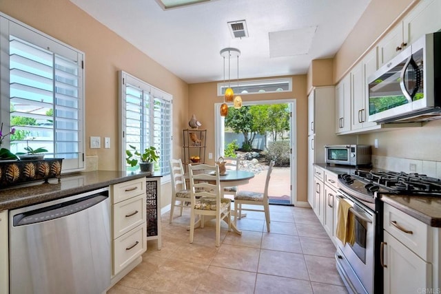 3376 Corsica Way, Oceanside, CA 92056 - kitchen with appliances with stainless steel finishes, dark countertops, white cabinets, decorative light fixtures, and light tile patterned floors