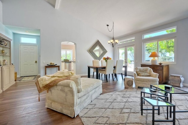 3376 Corsica Way, Oceanside, CA 92056 - living area featuring a chandelier, light wood-style floors, arched walkways, and high vaulted ceiling