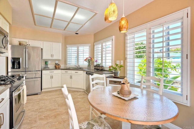 3376 Corsica Way, Oceanside, CA 92056 - kitchen with appliances with stainless steel finishes, dark countertops, white cabinetry, and decorative light fixtures