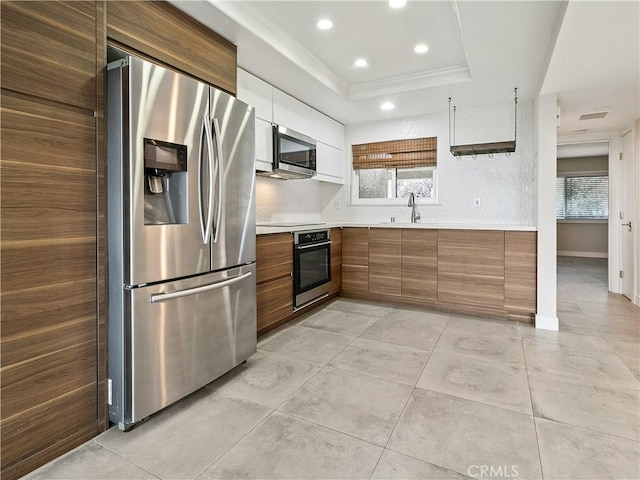 4026 Calle Sonora Este Unit 2F, Laguna Woods, CA 92637 - kitchen featuring stainless steel appliances, ornamental molding, light countertops, a sink, and brown cabinetry