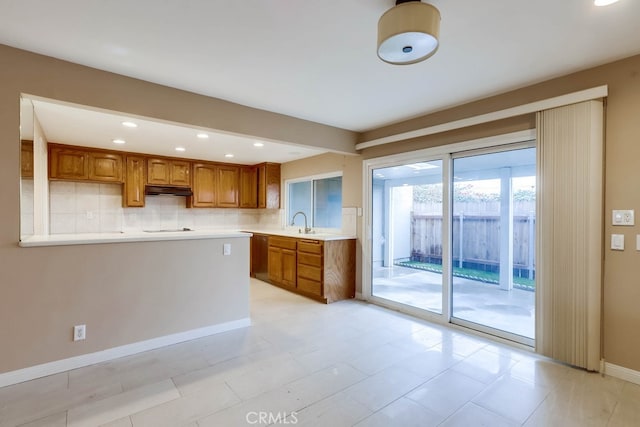 4714 Larwin Ave, Cypress, CA 90630 - kitchen featuring brown cabinets, backsplash, light countertops, recessed lighting, and under cabinet range hood
