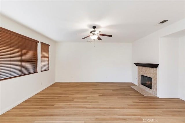 21567 Coral Rock Ln, Wildomar, CA 92595 - unfurnished living room with ceiling fan, a fireplace, light wood-style floors, and baseboards
