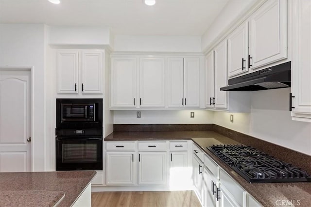 21567 Coral Rock Ln, Wildomar, CA 92595 - kitchen with black appliances, under cabinet range hood, white cabinetry, recessed lighting, and dark stone counters