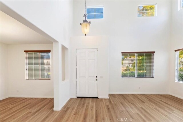21567 Coral Rock Ln, Wildomar, CA 92595 - foyer with a high ceiling, wood finished floors, and baseboards