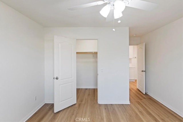 21567 Coral Rock Ln, Wildomar, CA 92595 - unfurnished bedroom featuring light wood-type flooring, baseboards, a closet, a walk in closet, and a ceiling fan