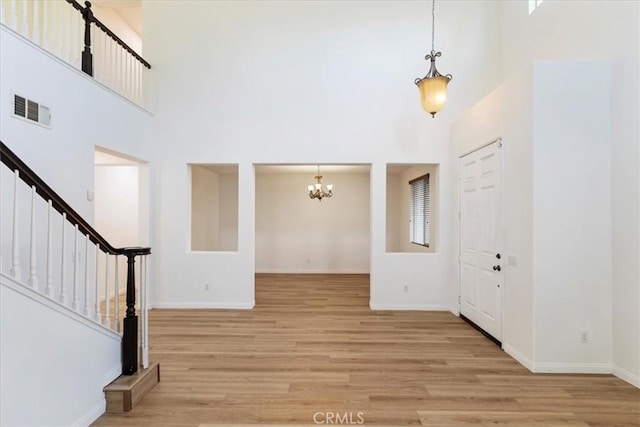 21567 Coral Rock Ln, Wildomar, CA 92595 - entrance foyer featuring a chandelier, a towering ceiling, light wood-style floors, and baseboards