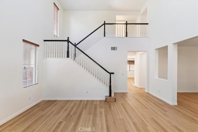 21567 Coral Rock Ln, Wildomar, CA 92595 - unfurnished living room with plenty of natural light, wood finished floors, baseboards, stairs, and a high ceiling