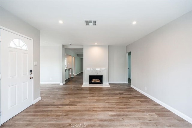 10113 Harvest Ave, Santa Fe Springs, CA 90670 - unfurnished living room with baseboards, light wood-style floors, recessed lighting, and a high end fireplace