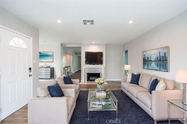 10113 Harvest Ave, Santa Fe Springs, CA 90670 - living area with wood finished floors, recessed lighting, and a fireplace