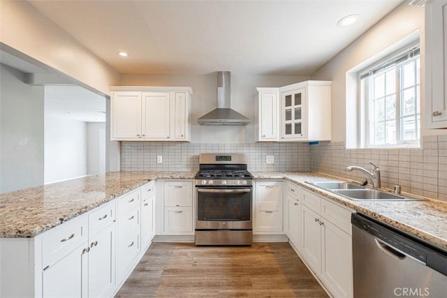 10113 Harvest Ave, Santa Fe Springs, CA 90670 - kitchen featuring wall chimney range hood, stainless steel appliances, a sink, white cabinets, and light wood finished floors