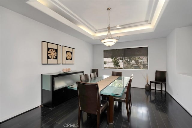 12841 Bloomfield St Unit 103, Studio City, CA 91604 - dining space featuring a tray ceiling, dark wood-style flooring, and baseboards