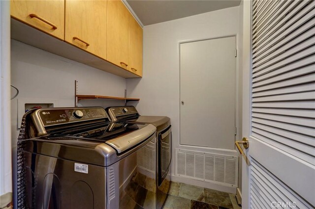 12841 Bloomfield St Unit 103, Studio City, CA 91604 - washroom featuring cabinet space, washer and dryer, stone finish floors, and baseboards