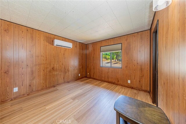 58632 Rainbow Dr, North Fork, CA 93643 - spare room featuring an AC wall unit, wood finished floors, and wooden walls