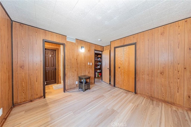 58632 Rainbow Dr, North Fork, CA 93643 - empty room with wood finished floors, wood walls, and a wood stove