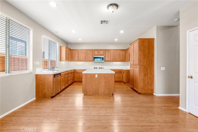 33010 Poppy St, Temecula, CA 92592 - kitchen with stainless steel appliances, a center island, light countertops, a sink, and light wood finished floors
