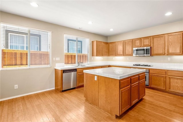 33010 Poppy St, Temecula, CA 92592 - kitchen with stainless steel appliances, tile counters, a sink, light wood-type flooring, and a kitchen island
