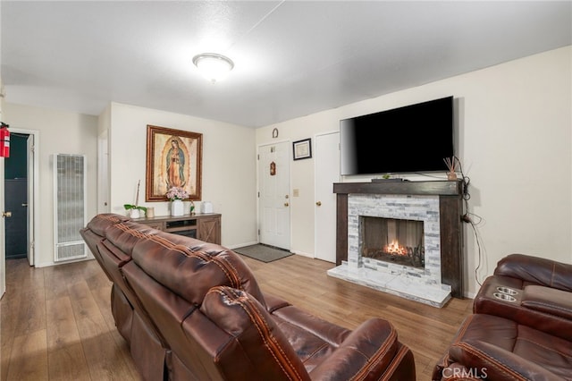 26166 Alpine Ln, Twin Peaks, CA 92391 - living area featuring a heating unit, a warm lit fireplace, wood finished floors, and baseboards